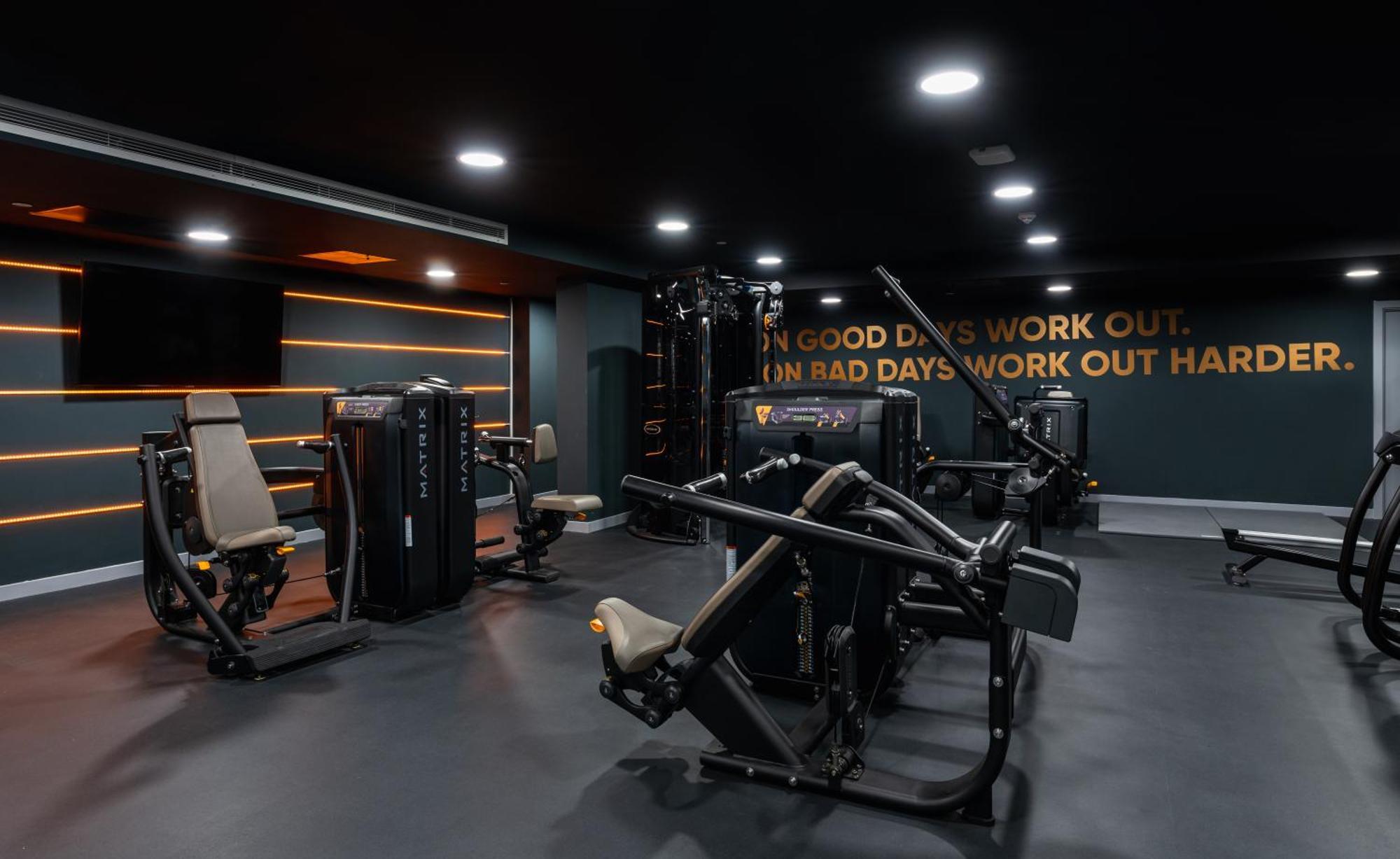 Citysuites 2 Aparthotel 맨체스터 외부 사진 The photo shows a modern gym interior. The gym features various exercise machines, including weight training equipment. The flooring is dark, and the walls are adorned with motivational text that reads, "ON GOOD DAYS WORK OUT. ON BAD DAYS WORK OUT HA